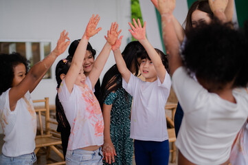 teacher and children playing color in Art join hand in hand fun together