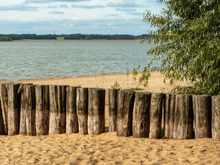 Bathing beach at the Bautzen Reservoir. The beautiful landscape is a travel destination for tourists. Clouds are on the sky. The calm blue body of water is an idyllic place in Saxony.