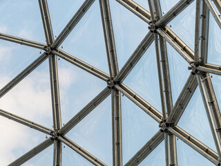 Steel and glass facade in a creative design. Architecture of an architectural dome. Building interior with a detail of the construction. Close-up of the structure of a concept.