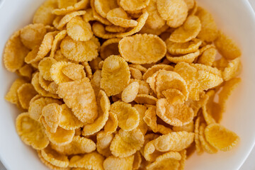 close up view of bowl with crispy yellow corn flakes.