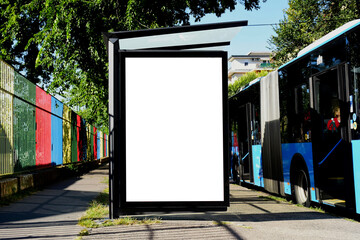 Bus shelter and bus stop on urban street. empty glass lightbox. lush green city street in the...