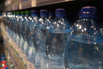 Spring water on a supermarket shelf in plastic bottles. Closeup selective focus.