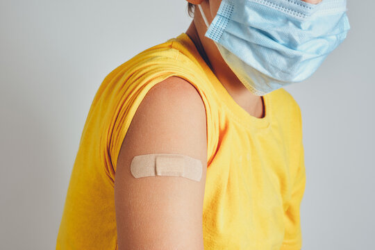 Close-up of a child shoulder with a band-aid after vaccination or injection of antibiotics.