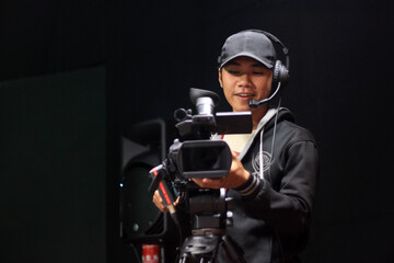 Cameraman with a camera on a tripod at studio