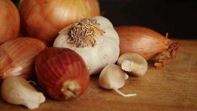 Different types of onion with garlic close up on wooden board