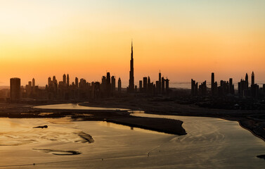 Naklejka na ściany i meble Aerial sunset Dubai city skyscrapers reclaimed desert landscape