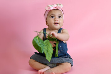 Obraz na płótnie Canvas baby little girl holding a leaf