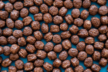 Fototapeta na wymiar top view of tasty cereal balls with chocolate flavor on blue.