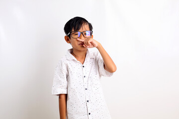 Asian little boy standing while showing bad smell expression gesture. Isolated on white background