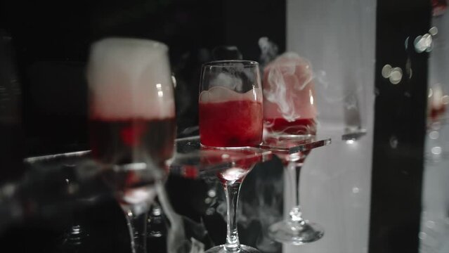 Dry ice in cocktails. Champagne glasses at the party. Sparkling alcoholic wine at the night event. Relaxing and drink, have fun tonight.