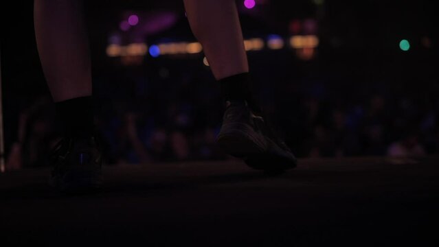 DJ dancing on festival stage (feet close up)