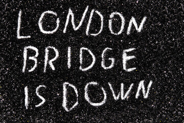 Fototapeta na wymiar It is code name of the operation when the Queen of the England die written on the black glitter - LONDON BRIDGE IS DOWN.