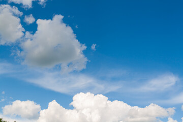 Naklejka na ściany i meble Summer sky. Natural background of white clouds on a blue sky.