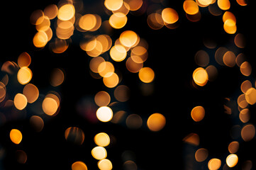 Yellow abstract bokeh made from Christmas lights on black isolated background. Holiday concept,...