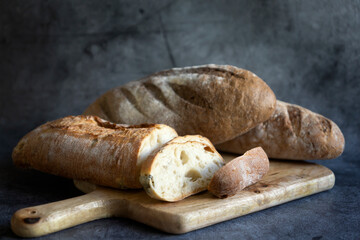 Bread, traditional sourdough bread cut into slices on a rustic wooden background. Concept of traditional leavened bread baking methods. Healthy food.