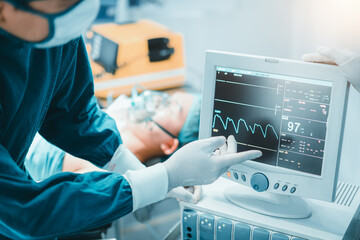 Two professional surgeon doctor perform surgery operation look at Electrocardiogram monitor show...