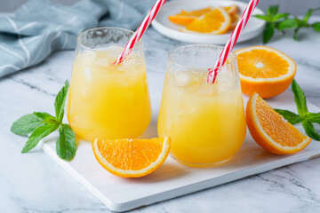 Naklejka na ściany i meble Glass of orange juice with ice. Cold orange fresh. Glass of orange juice