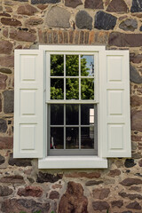 Windows with shutters on old stone house.