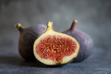 Ripe, sweet figs whole and cut on a dark background.