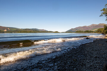 Fototapeta na wymiar The shore of a calm lake in the Lake District on a summer sleepy day