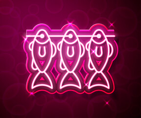 Glowing neon line Dried fish icon isolated on red background. Vector
