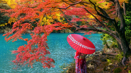 Asian woman wearing japanese traditional kimono at Arashiyama in autumn season along the river in...