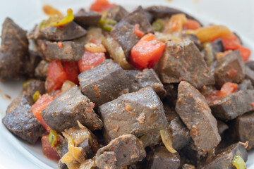 Asian cuisine, fine dining - close-up, fried tender lamb livers on a copper plate.