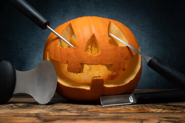 Halloween pumpkin carving tools spoon gutter and saw blades, with carved Jack Lantern...