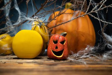Two yellow gym dumbbells, small ceramic Halloween Jack O Lantern figurine and autumn pumpkin in...