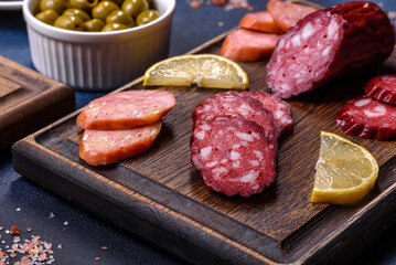 Delicious fresh smoked sausages cut with slices on a wooden cutting board