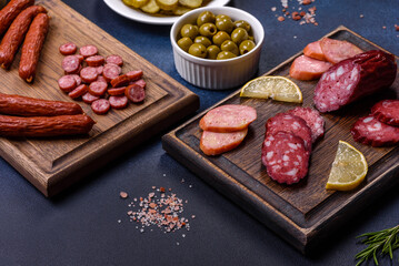 Delicious fresh smoked sausages cut with slices on a wooden cutting board