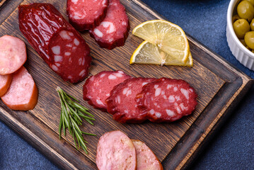 Delicious fresh smoked sausages cut with slices on a wooden cutting board