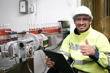 engineer worker working together with safety uniform and white helmet to work in industry factory handle tablet. Factory worker inspecting production line of drink production in factory. indian men