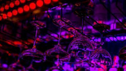 Glasses of cocktails. Glasses hanging above the bar in the restaurant.