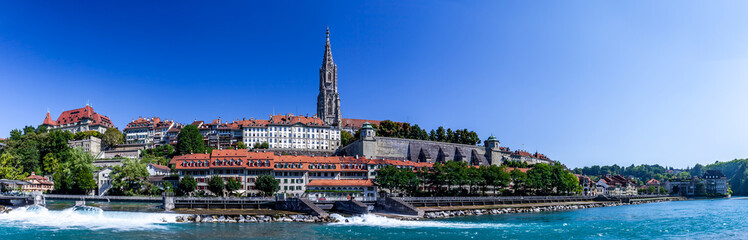Obraz premium BERN, SWITZERLAND - August 8th 2022: Panoramic view of Bern and Berner Munster cathedral in a beautiful summer day, Switzerland