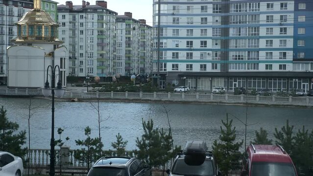 Lake Among Houses in Residential Area. Cars Paked on Parking Lot near Apartment Buildings Block of Flats. Overcast Day. Ukraine Ivano-Frankivsk. 2x Slow motion 60 fps 4K