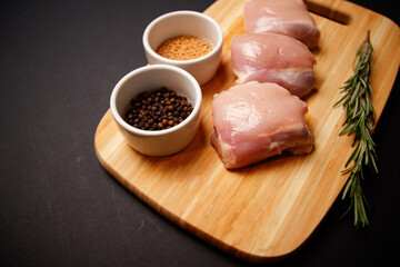 Raw chicken thigh on black background