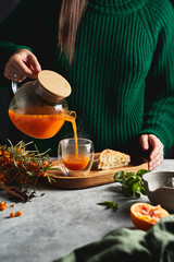 a girl in a green sweater pours a hot drink