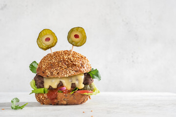 Halloween party burger in shape of scary monster. Halloween food concept.