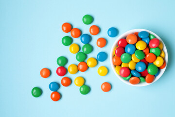 Vessel with Color Candies on blue background