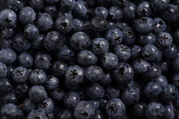 a heap of fresh ripe wet blueberries filling the frame, selective focus, top view, background