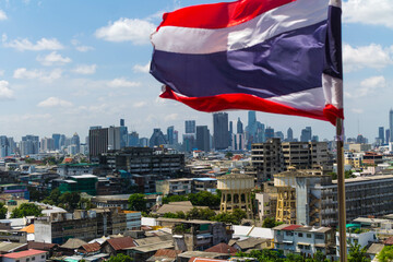bandera tailandesa ondeando con bangkok al fondo