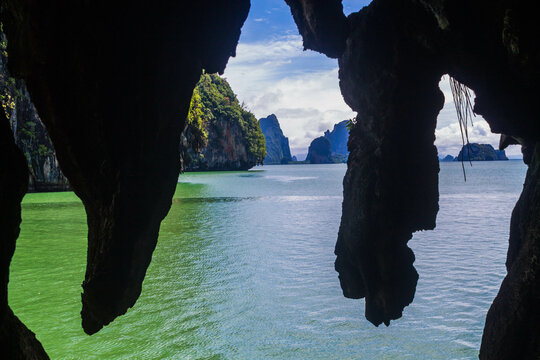 mirando tras las rocas en la cueva al mar azul