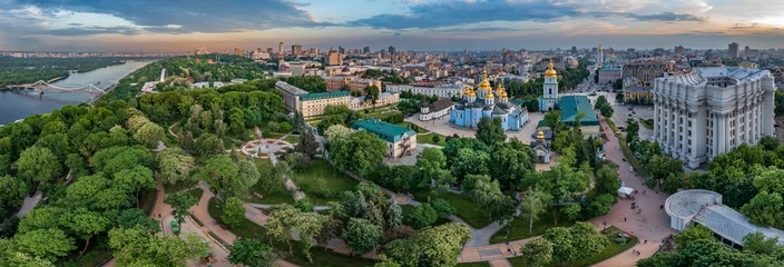 Fototapeten Panorama of Kyiv with a beautiful view of the center of the capital and the Dnieper River at sunset on a summer day, Ukraine. Aerial view. © underwaterstas