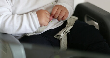 Baby todlder fastened belt on highchair, infan thands holding belt