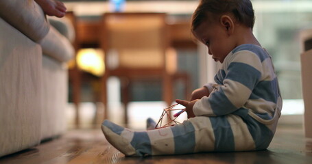 Baby infant boy at night wearing pijamas playing with object