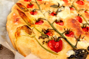 appetizing focaccia bread with cherry tomatoes and basil selective focus, homemade bread