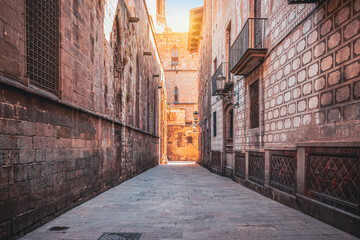 Narrow street with historic architecture close to cathedral in Barcelona city center, Spain.