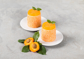 Apricot mousse dessert of cylindrical shape with turbillon jelly on top, sprinkled with colored...