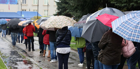  Ludzie pod parasolami czekają w kolejce do mobilnego punktu szczepień we Wrocławiu - obrazy, fototapety, plakaty